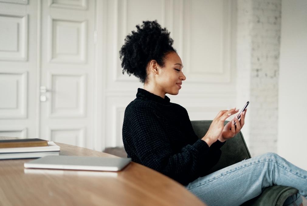 Woman smiling and working on mobile phone