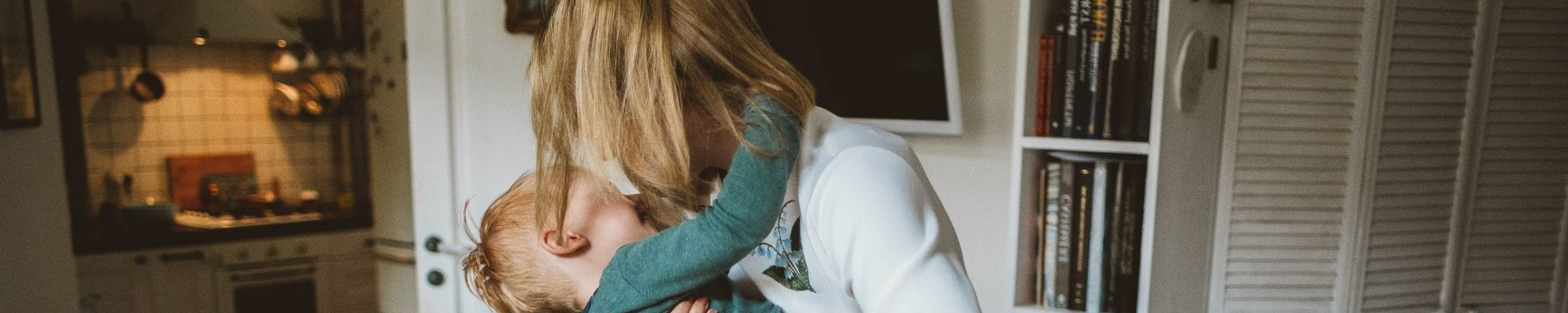 Mother embracing child in home