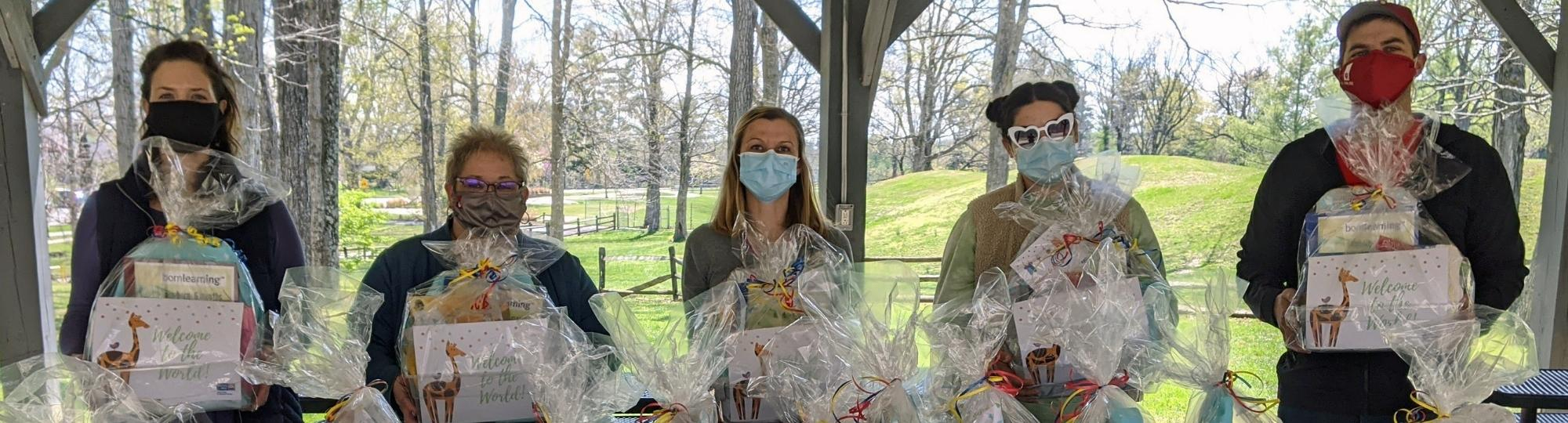 Group of volunteers holding baskets for new moms