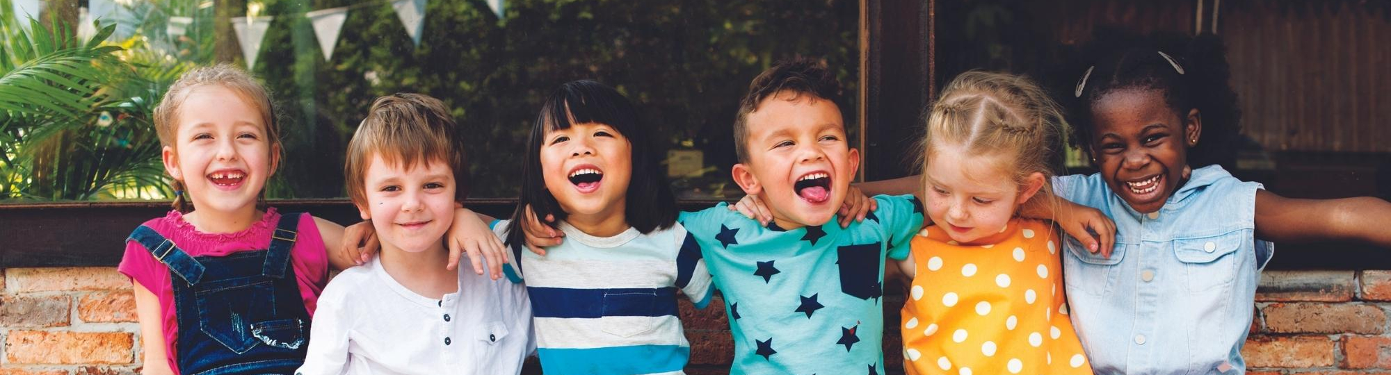 Kids sitting on a bench smiling