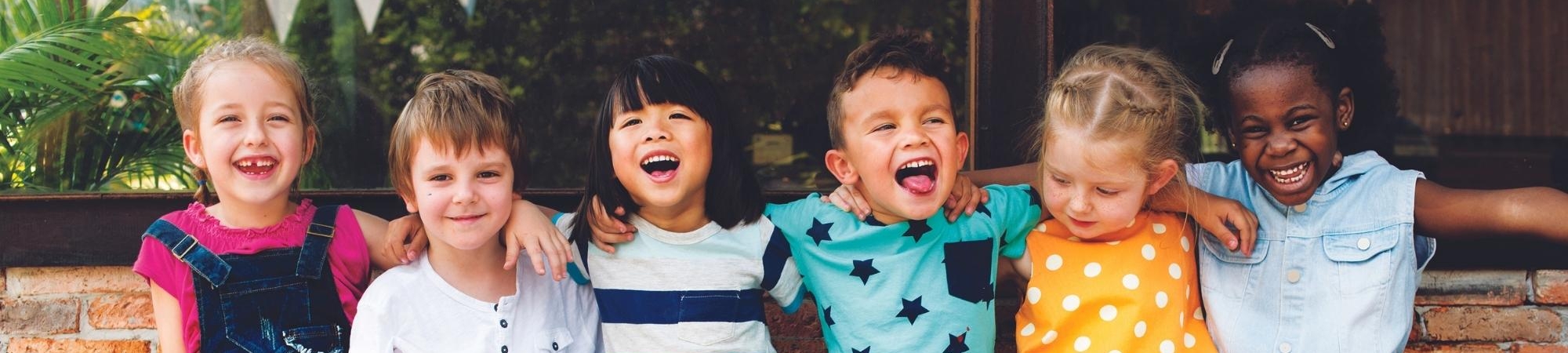 Kids sitting on a bench smiling