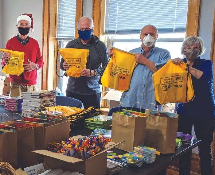 Volunteers holding up backpacks